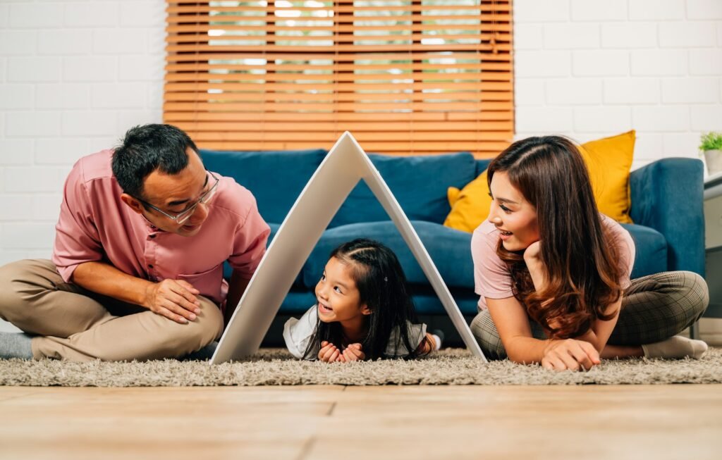 Happy family holding symbolic cardboard roof of life insurance