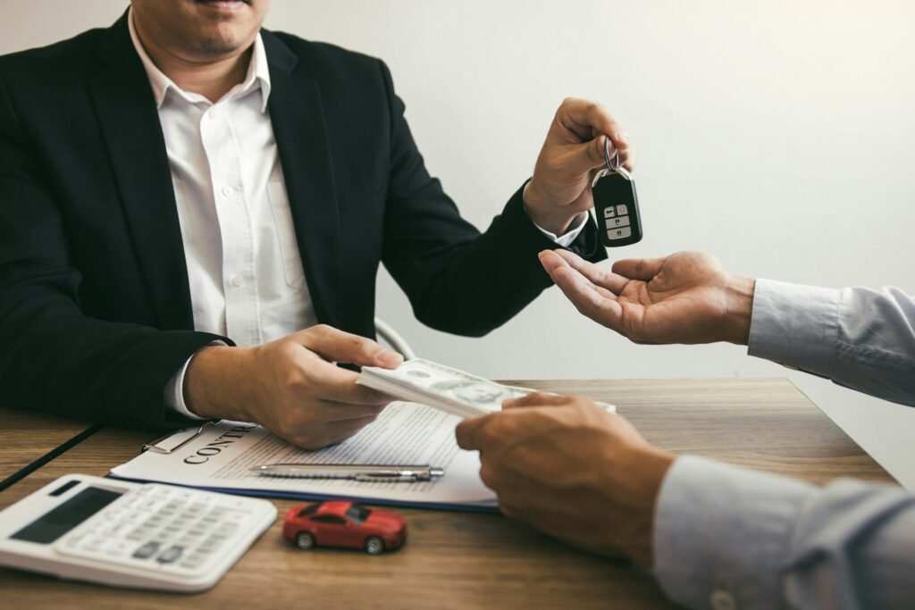 New car buyers and car sales agent people are exchanging by giving cash and new car keys